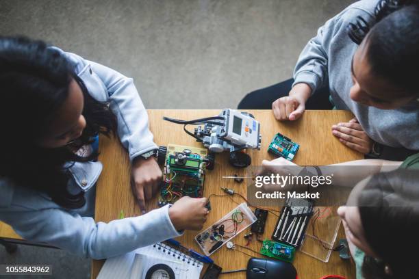 high angle view of multi-ethnic female students preparing science project at desk in high school classroom - mint stock-fotos und bilder