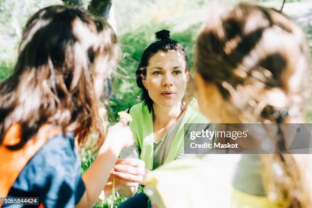 high angle view of teacher talking with girls in playground - nursery school building stock pictures, royalty-free photos & images