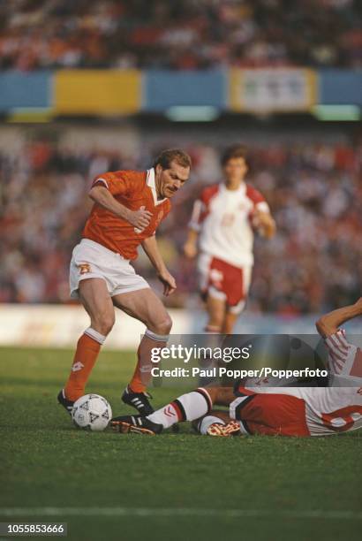 Dutch professional footballer Jan Wouters, midfielder with FC Bayern Munich, pictured with the ball for the Netherlands team as Danish player Kim...