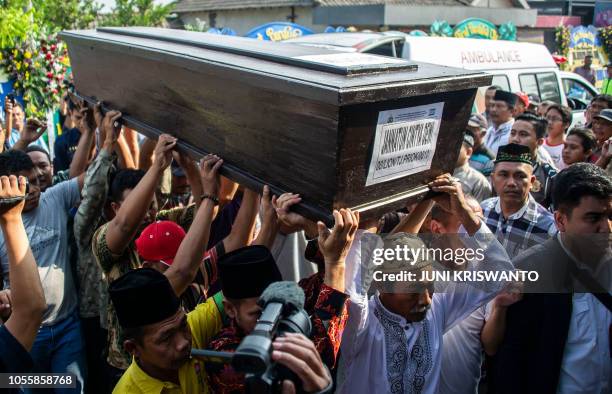 Family members carry the coffin of Jannatun Cintya Dewi, who was a passenger on the ill-fated Lion Air flight JT 610 which crashed on October 29,...