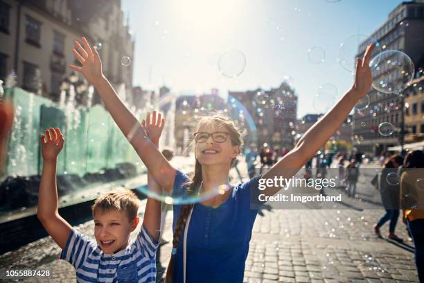 kids enjoying bubbles in market square in wrocław, poland - breslau stock pictures, royalty-free photos & images