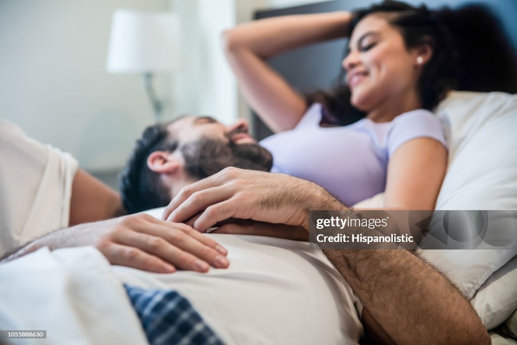 Joven Pareja Relajarse En La Cama Hablando Mientras Que El Hombre Está Acostado En El Vientre De La Mujer Ambos Mirando El Uno Al Otro Mientras Habla Foto de stock - Getty Joven Pareja Relajarse En La Cama Hablando Mientras Que El Hombre Está Acostado En El Vientre De La Mujer Ambos Mirando El Uno Al Otro Mientras Habla Foto de stock - Getty