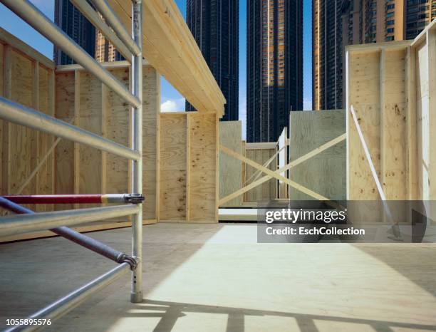 timber construction skeleton at a neat construction site in residential area - baustelle gerüst sonne stock-fotos und bilder