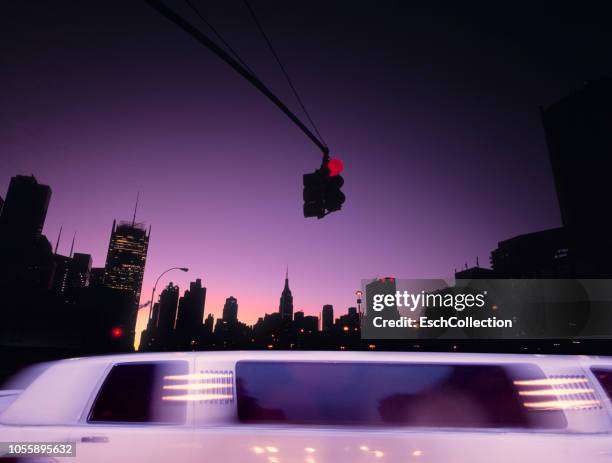 limousine car passing junction in midtown manhattan at sunrise - limo stockfoto's en -beelden