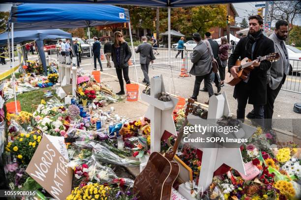 Guitarist stood passionately singing for hours. Outside the Tree of Life, many come to pay their respects whether it be rain or shine. Musicians from...