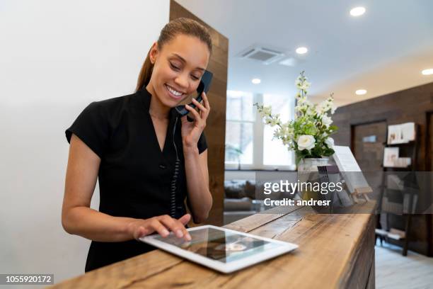 woman working at a spa talking on the phone - hotel stock pictures, royalty-free photos & images