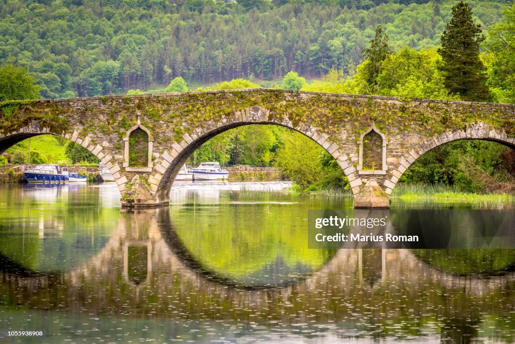 Beautiful Graiguenamanagh stone bridge with trees in the background on a rainy day, County Kilkenny, Ireland.