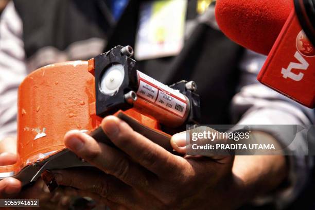 This picture from Indonesia media agency "detikcom" shows officials displaying part of the ill-fated Lion Air flight JT 610's black box, an FDR ,...