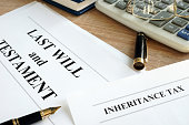 Inheritance tax and last will and testament on a desk.