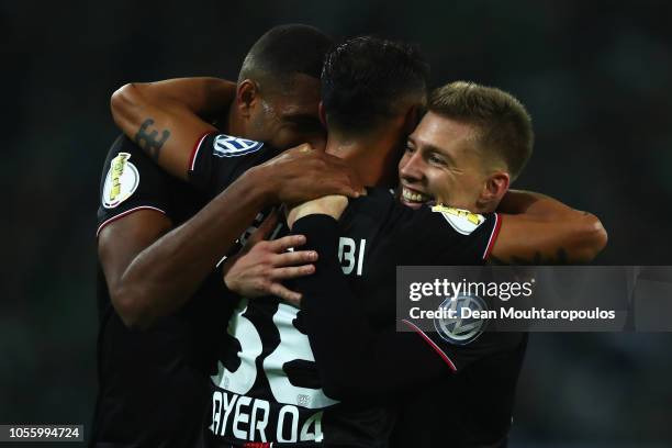 Karim Bellarabi of Bayer Leverkusen celebrates with his team mates Jonathan Tah and Mitchell Weiser after scoring his side's third goal during the...