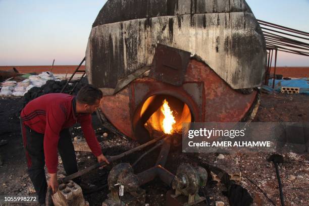 Syrian man works on October 31, 2018 at a primitive oil facility in the town of Zardana in the countryside of the northwestern Syrian Idlib province...