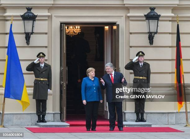Ukrainian President Petro Poroshenko and German Chancellor Angela Merkel talk during the welcoming ceremony before their meeting in Kiev on November...