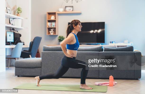 woman exercising at home - lunge imagens e fotografias de stock
