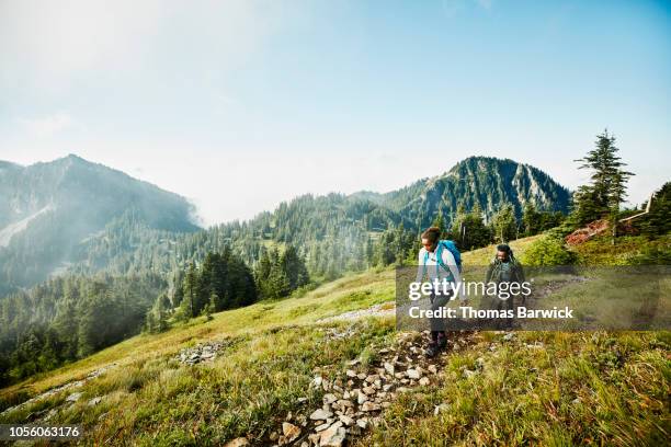 daughter leading father on morning hike up mountainside - hiking 個照片及圖片檔