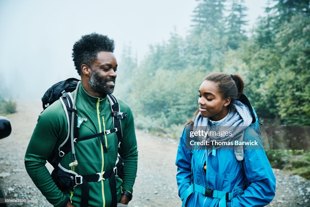 Smiling father and daughter preparing for early morning hike