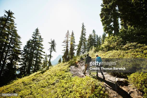 father and daughter hiking on trail through forest - backpacker road stock pictures, royalty-free photos & images