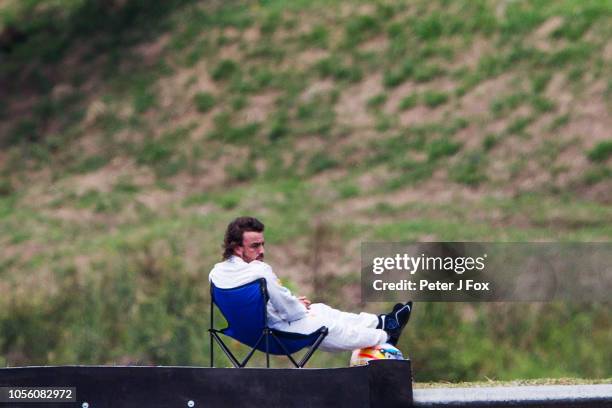 Fernando Alonso of McLaren and Spain sits on a deckchair after suffering car breakdown during final qualifying for the Formula One Grand Prix of...