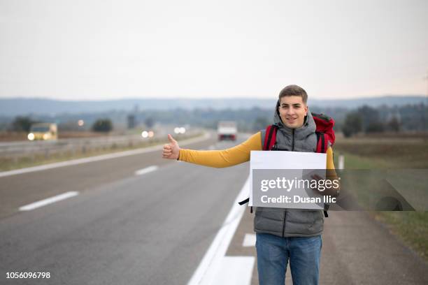 mann mit leeren karton beim trampen - trampen stock-fotos und bilder