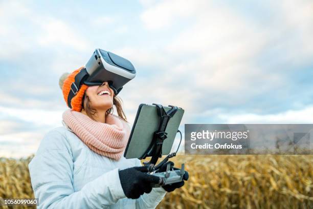 lunettes femme pilote à l’aide de drone télécommande avec une réalité tablet monter et virtuelle - casques réalité virtuelle photos et images de collection
