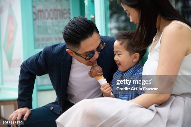 father stealing ice cream from his son - australia city lifestyle stock-fotos und bilder