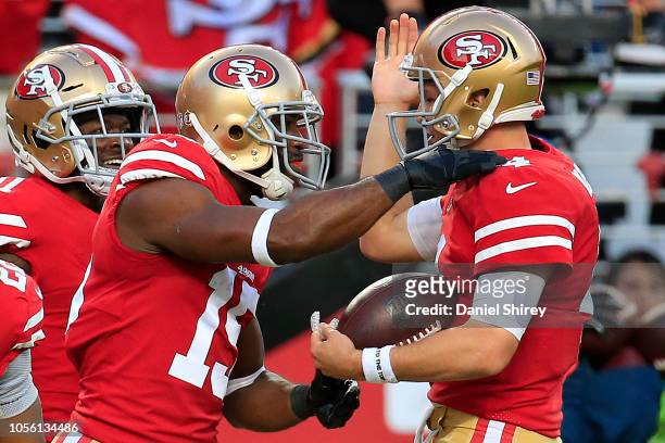 Pierre Garcon of the San Francisco 49ers celebrates with Nick Mullens after a 24-yard touchdown against the Oakland Raiders during their NFL game at...
