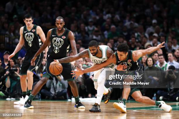 Kyrie Irving of the Boston Celtics and Malcolm Brogdon of the Milwaukee Bucks battle for a loose ball during the second half at TD Garden on November...