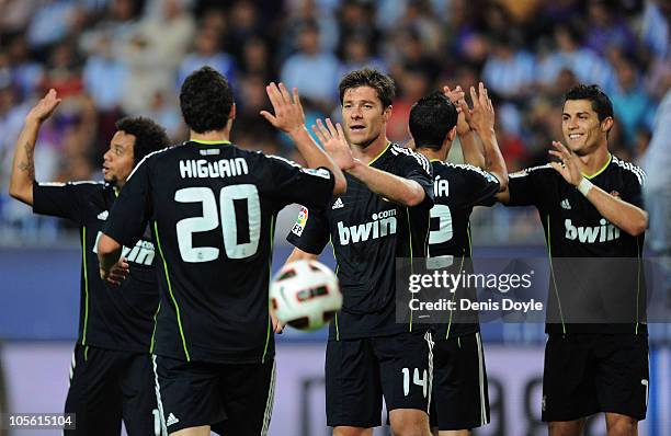 Xabi Alonso of Real Madrid celebrates with Gonzalo Higuain after Real scored their fourth goal during the La Liga match between Malaga and Real...