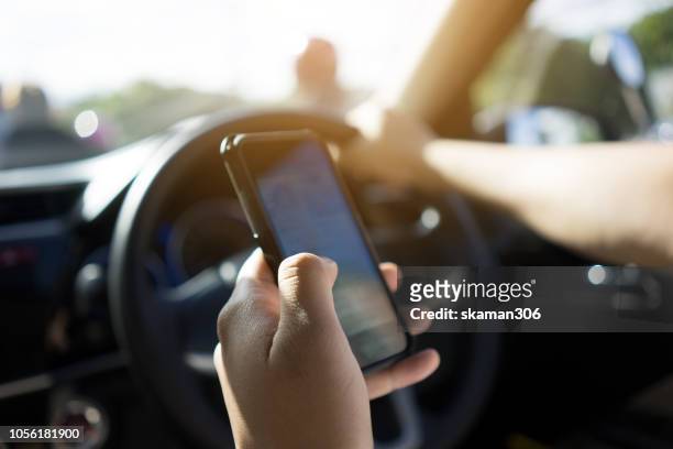 unsafe and danger driver use smartphone or cellphone and driving car with traffic - distracted driving stock pictures, royalty-free photos & images