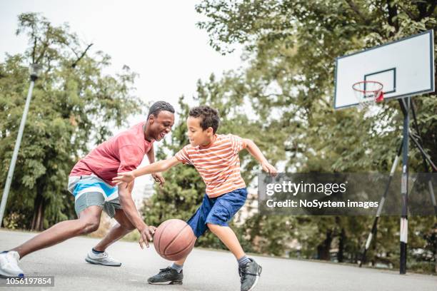 father and son playing basketball - basketball action stock pictures, royalty-free photos & images