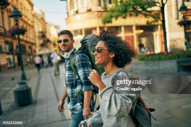junge rucksacktouristen in der stadt - rucksacktourist stock-fotos und bilder