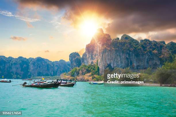 beau coucher de soleil en mer tropicale avec bateau longue queue dans le sud de la thaïlande - phuket beach photos et images de collection