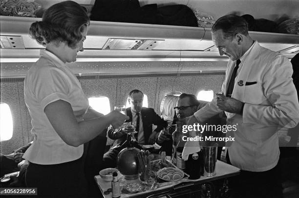 Steward and Stewardess serving drinks during a proving flight between Heathrow and Khartoum, 1st February 1964.