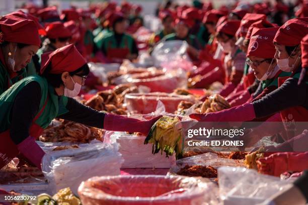 Volunteers take part in a kimchi making festival in Seoul on November 2, 2018. - The traditional Korean dish of spicy fermented cabbage and radish...