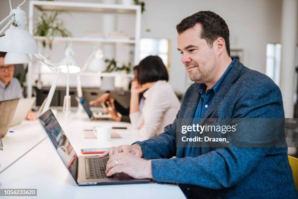 portrait of mature businessman in co-working space - overweight man stock pictures, royalty-free photos & images