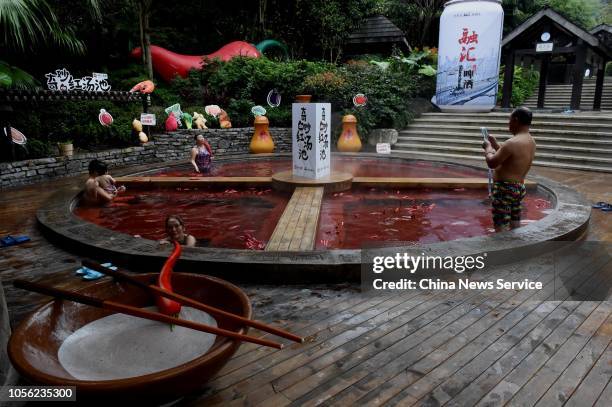 Citizens bath in a red hot spring in the shape of a giant hot pot at the Chongqing Ronghui Hot Spring Resort on October 18, 2018 in Chongqing, China....