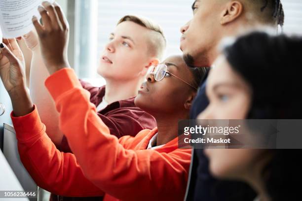 male and female university students checking test results on bulletin board - grade 4 stock pictures, royalty-free photos & images