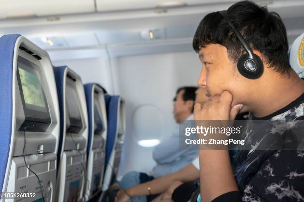 Young guy watches a movie on an airbus plane during flight from Xi'an to Lhasa.