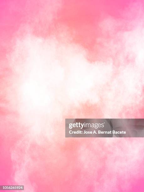 explosion by an impact of a cloud of particles of powder of color white on a pale pink background. - smog photos et images de collection
