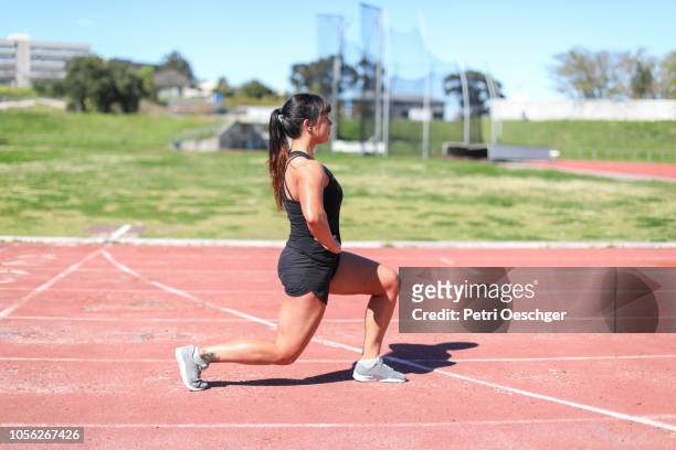 a fit young woman training at the track. - affondo foto e immagini stock