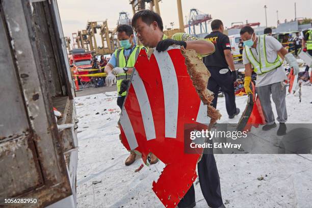 Man carries a piece of the Lion Air flight JT 610 wreckage containing part of the Lion Air logo at the Tanjung Priok port on November 2, 2018 in...