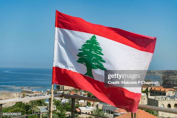 lebanese national flag waving in breeze, byblos, jbeil, lebanon - lebanese foto e immagini stock