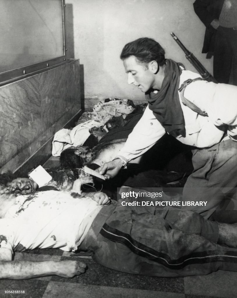 A partisan checking cards on Mussolini and Petacci