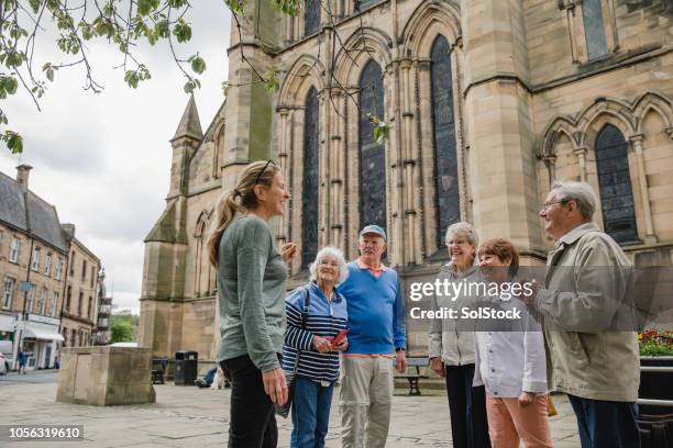 senior groep doen een tour in hexham - gids stockfoto's en -beelden