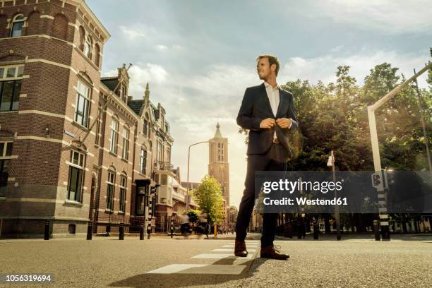 netherlands, venlo, businessman standing on a street - city from below stockfoto's en -beelden