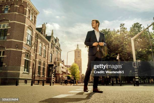 netherlands, venlo, businessman standing on a street - low angle view city stock pictures, royalty-free photos & images