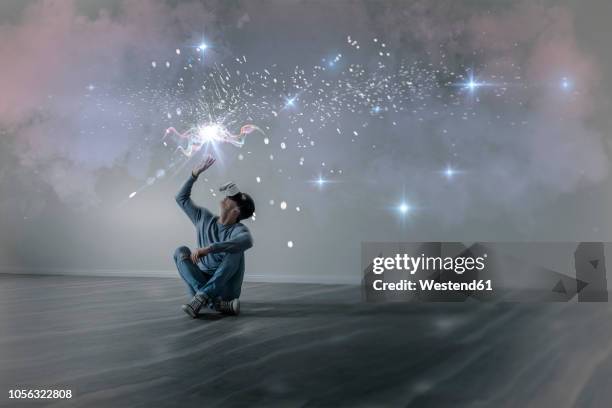 young man in empty apartment sitting on the floor using virtual reality glasses, composite - house shifting foto e immagini stock