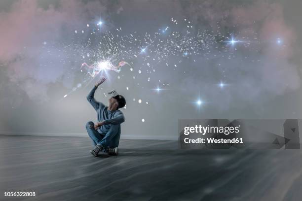 young man in empty apartment sitting on the floor using virtual reality glasses, composite - vr imagens e fotografias de stock