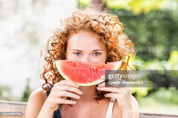 portrait of redheaded young woman with watermelon - fresh fruit stock-fotos und bilder