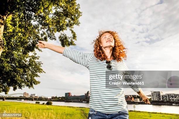 germany, cologne, young woman enjoying sunlight - wind river film 2017 stock-fotos und bilder