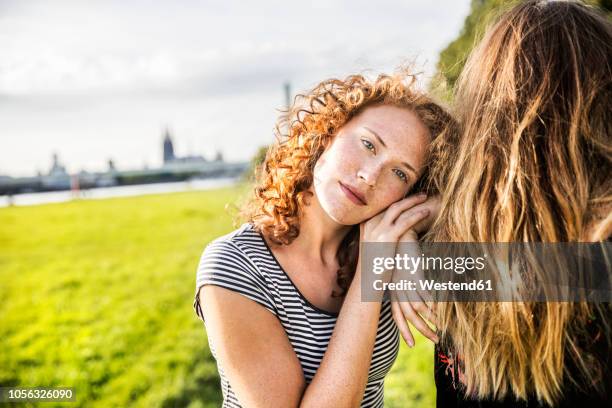 germany, cologne, portrait of redheaded young woman with friend - curly hair natural stock-fotos und bilder